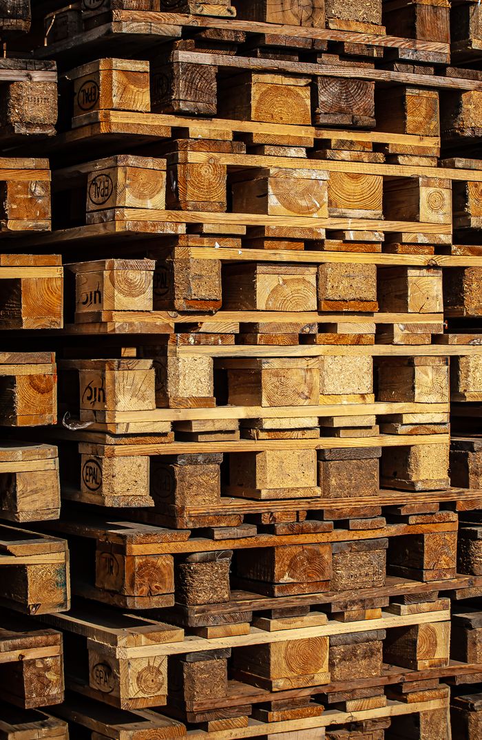 Close-up of stacked wooden pallets outdoors, showcasing industrial storage.